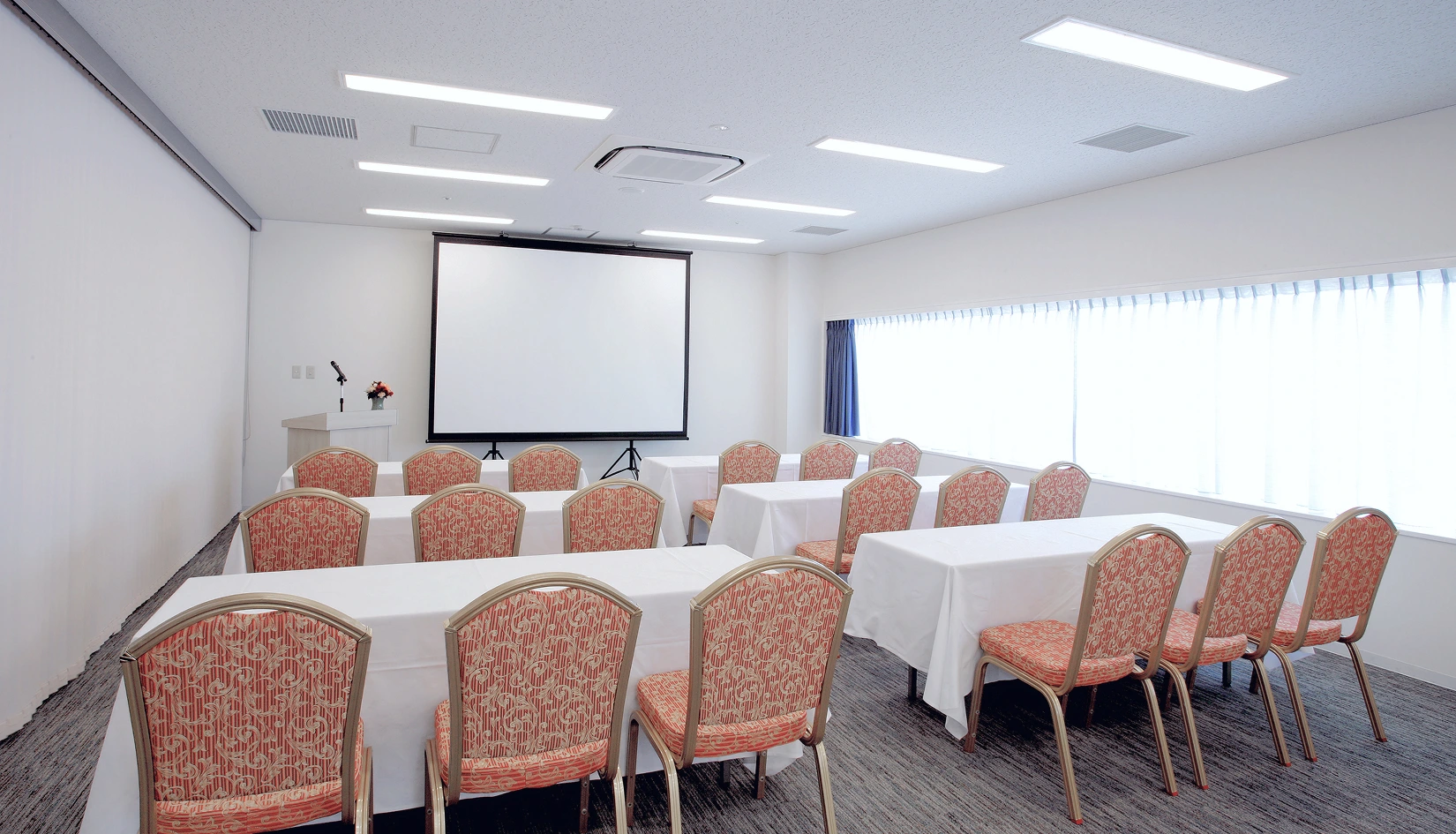 スクール形式でスクリーンを設置した会議室