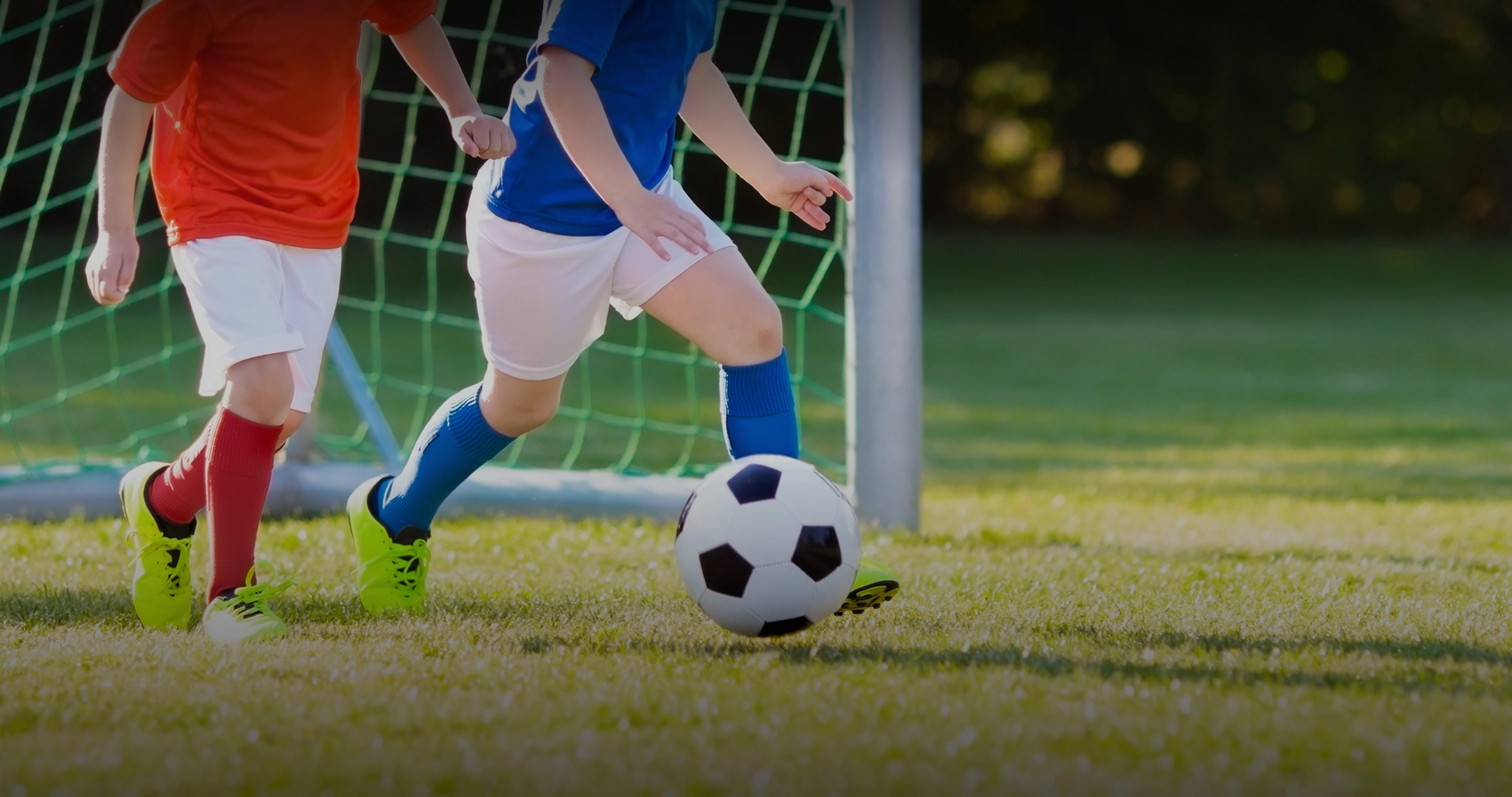 ゴール前でサッカーボールを追う子どもたち